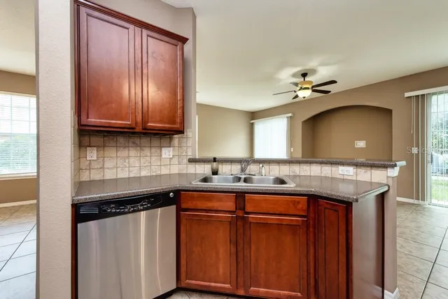 a kitchen with stainless steel appliances granite countertop a sink a stove cabinets and a counter top space