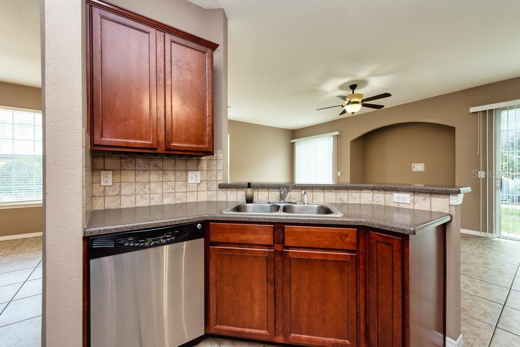 7525 Red Mill Circle New Port Richey, FL 34653 - Photo 12 of 41 a kitchen with stainless steel appliances granite countertop a sink a stove cabinets and a counter top space