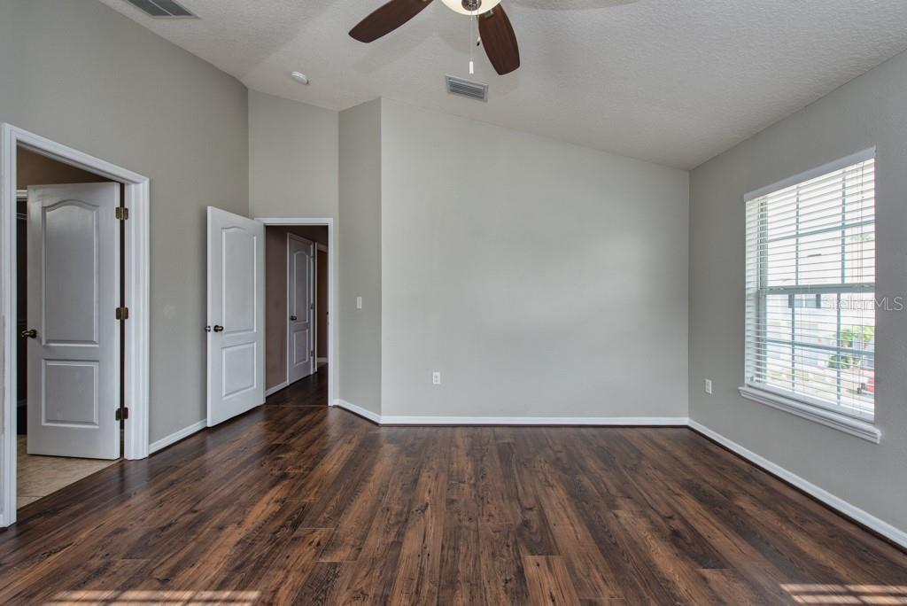 7525 Red Mill Circle New Port Richey, FL 34653 - Photo 18 of 41 wooden floor in an empty room with a window