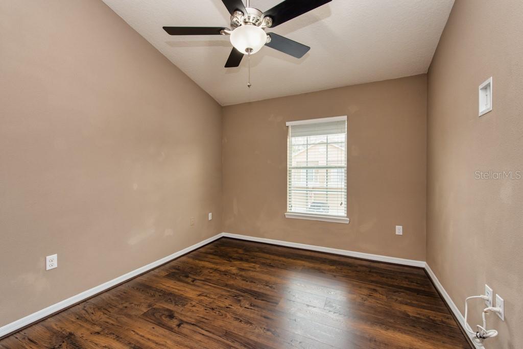 7525 Red Mill Circle New Port Richey, FL 34653 - Photo 21 of 41 an empty room with wooden floor and windows