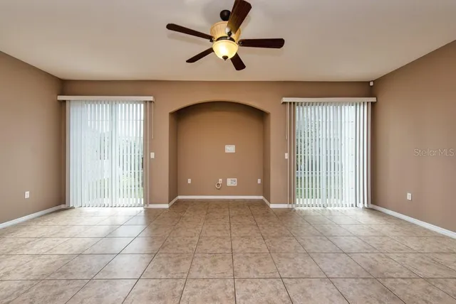 a view of a livingroom with a chandelier fan and windows