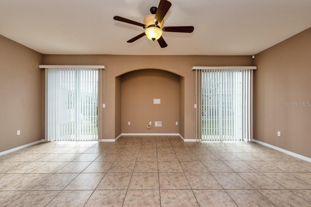 7525 Red Mill Circle New Port Richey, FL 34653 - Photo 4 of 41 a view of a livingroom with a chandelier fan and windows