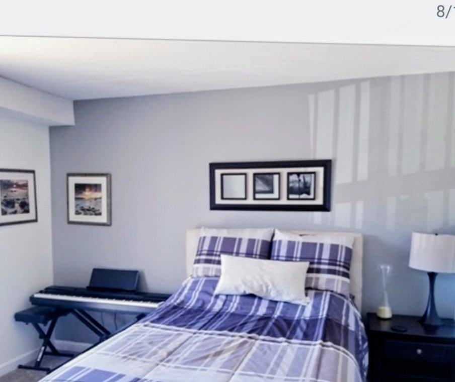 40 Main Street, Unit 308 Stoneham, MA 02180 - Photo 5 of 10 a bedroom with a bed and a lamp on dresser