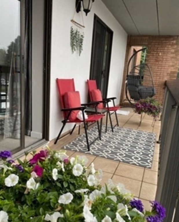 40 Main Street, Unit 308 Stoneham, MA 02180 - Photo 7 of 10 a patio with table and chairs and potted plants