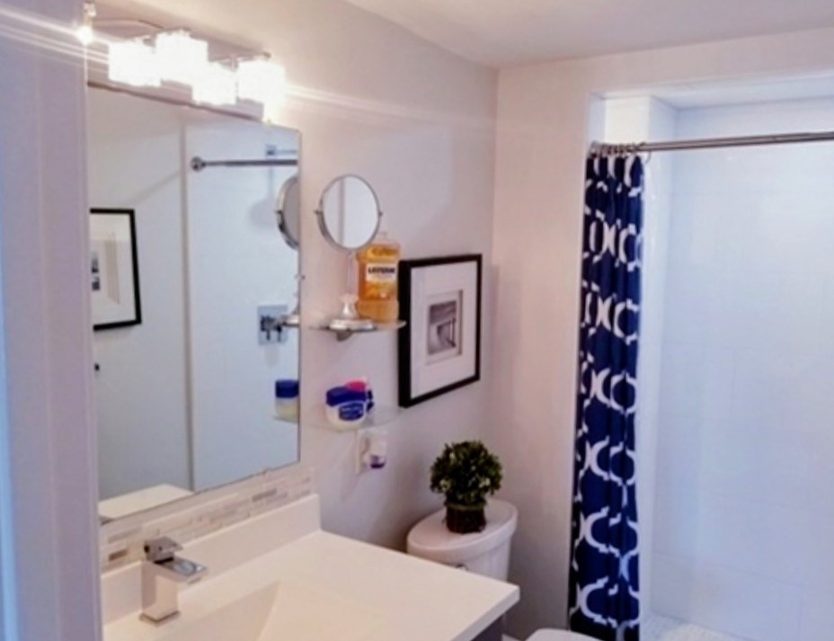 40 Main Street, Unit 308 Stoneham, MA 02180 - Photo 8 of 10 a bathroom with a sink mirror and vanity