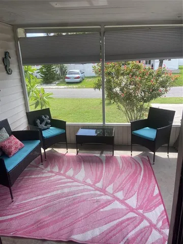 a view of a chairs and table in patio with swimming pool