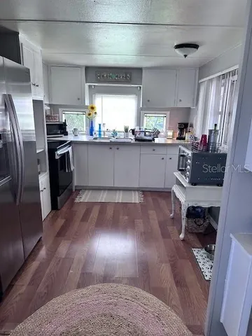 a kitchen with stainless steel appliances granite countertop a refrigerator a stove a sink and a oven