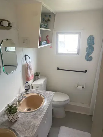 a bathroom with a toilet sink and mirror