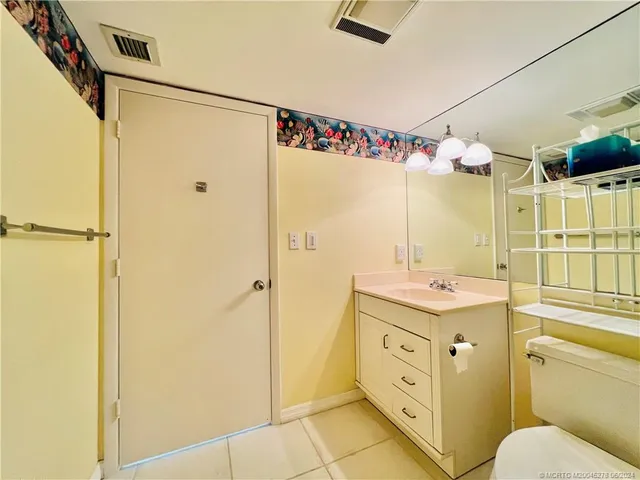 a bathroom with a granite countertop toilet sink and mirror