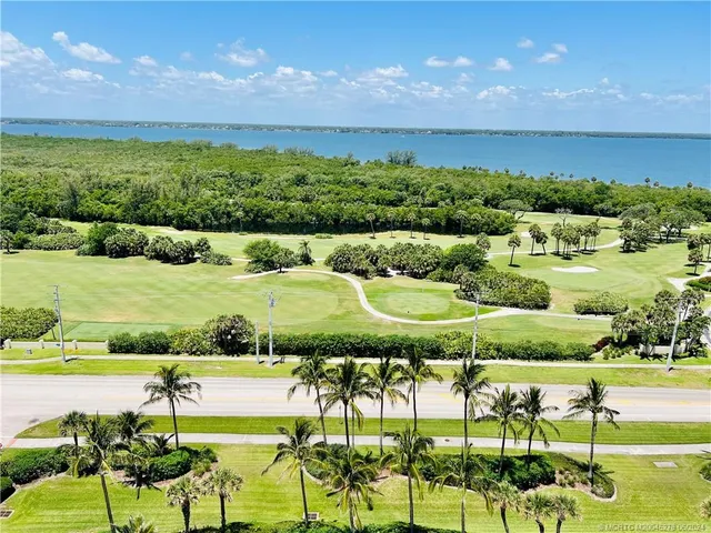 a living room with furniture and floor to ceiling window