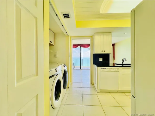 a kitchen with kitchen island a counter top space a sink a refrigerator and cabinets