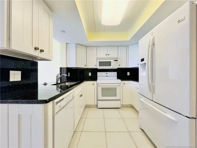 a kitchen with a sink a stove and cabinets