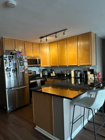 a kitchen with stainless steel appliances granite countertop a refrigerator a stove and a sink