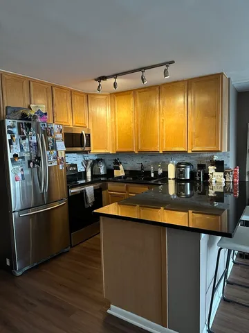 a kitchen with stainless steel appliances granite countertop a refrigerator a stove and a sink