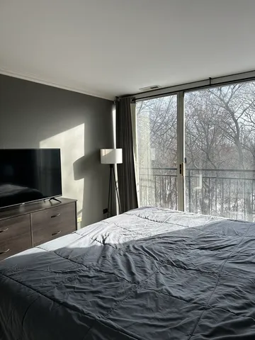 a bedroom with a bed and a large window