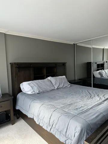 a large bed sitting in a bedroom next to a window