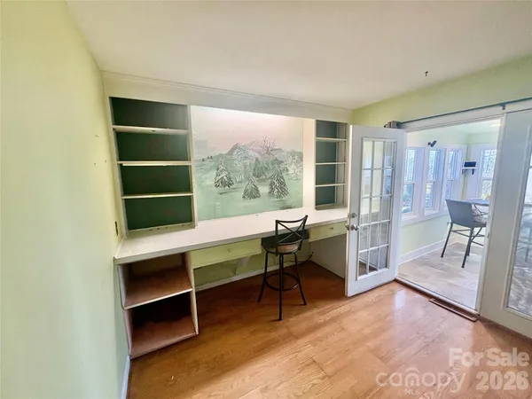 a view of a workspace with furniture and a window