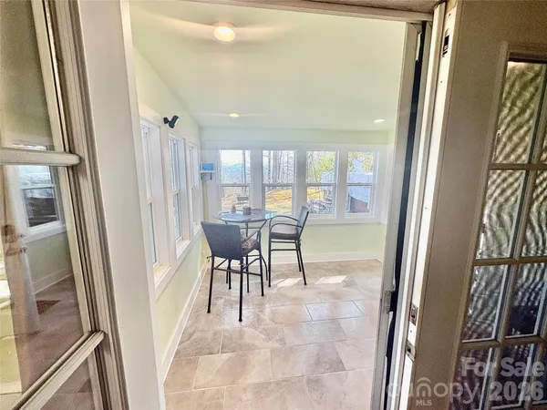 a view of a dining room with furniture a livingroom and front door