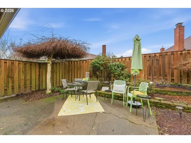 a backyard of a house with a table and chairs