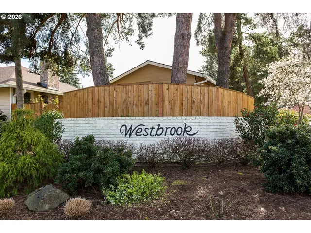 a sign that is sitting in front of a tree