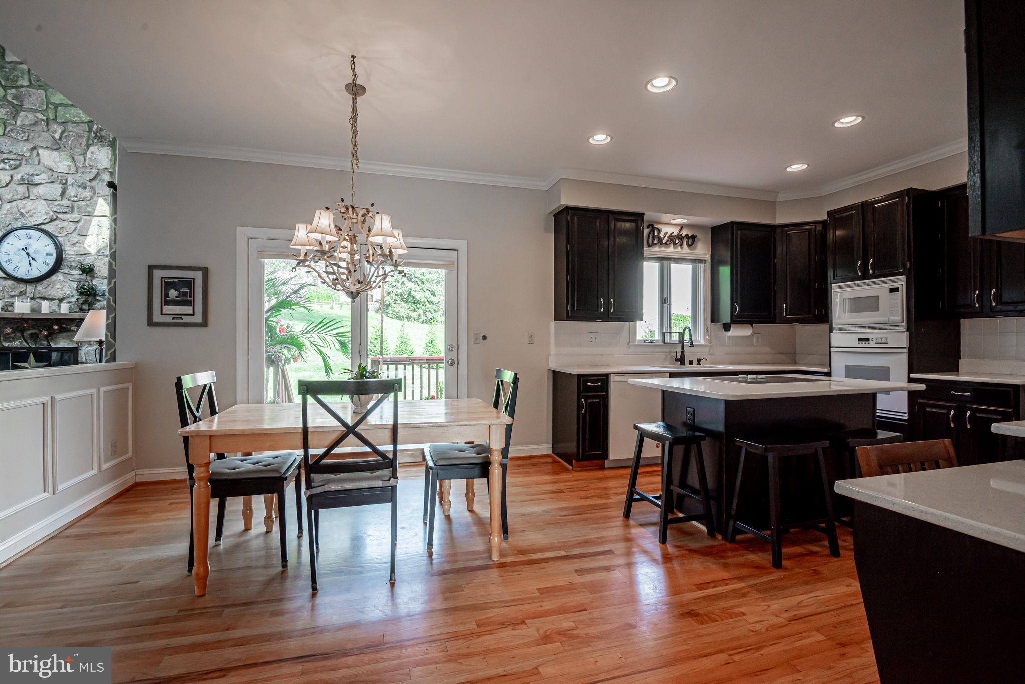 706 Regency Hill Road Hockessin, DE 19707 - Photo 16 of 54 a kitchen with stainless steel appliances granite countertop a stove top oven a sink dishwasher a dining table and chairs with wooden floor
