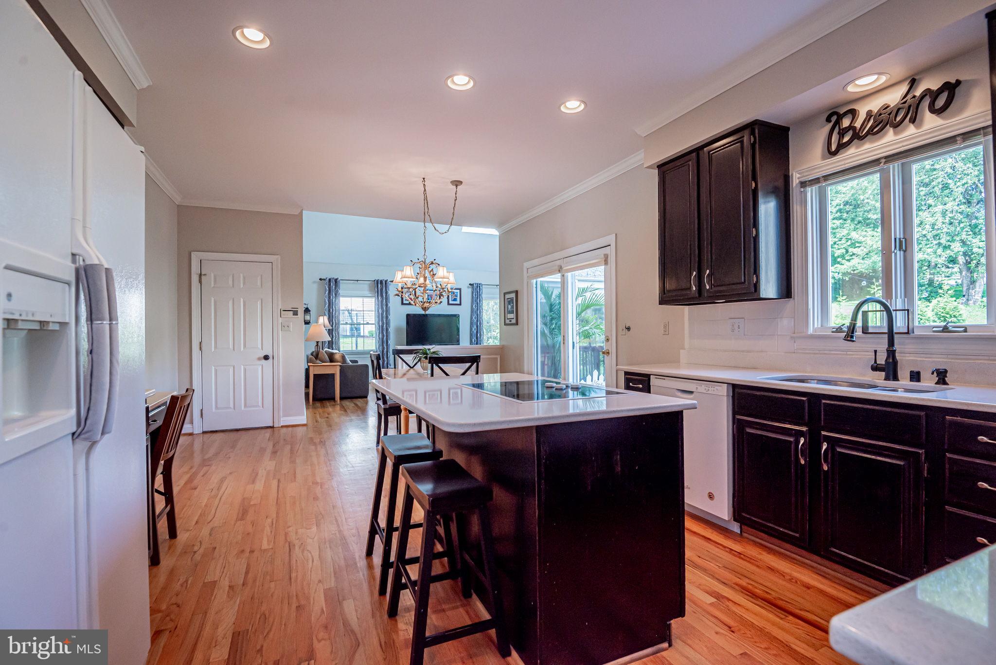 706 Regency Hill Road Hockessin, DE 19707 - Photo 19 of 54 a kitchen with stainless steel appliances a dining table chairs sink and wooden floor