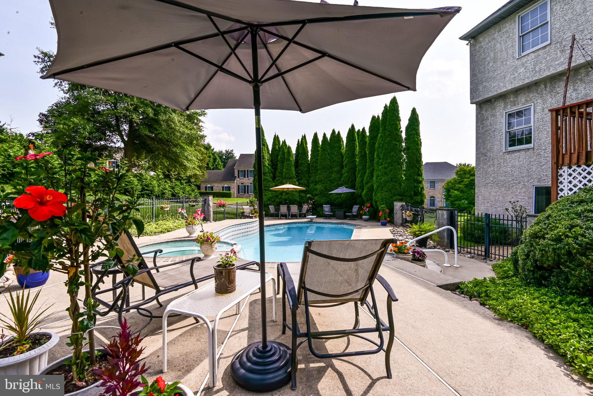 706 Regency Hill Road Hockessin, DE 19707 - Photo 42 of 54 a view of a chairs and table under an umbrella in the patio