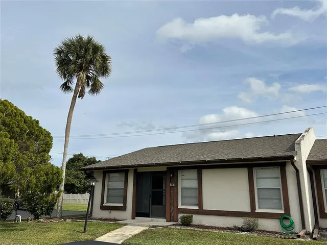 a front view of a house with a garden and trees