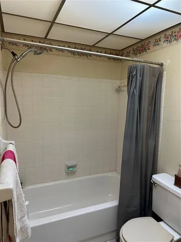 a bathroom with a shower a toilet and a tub
