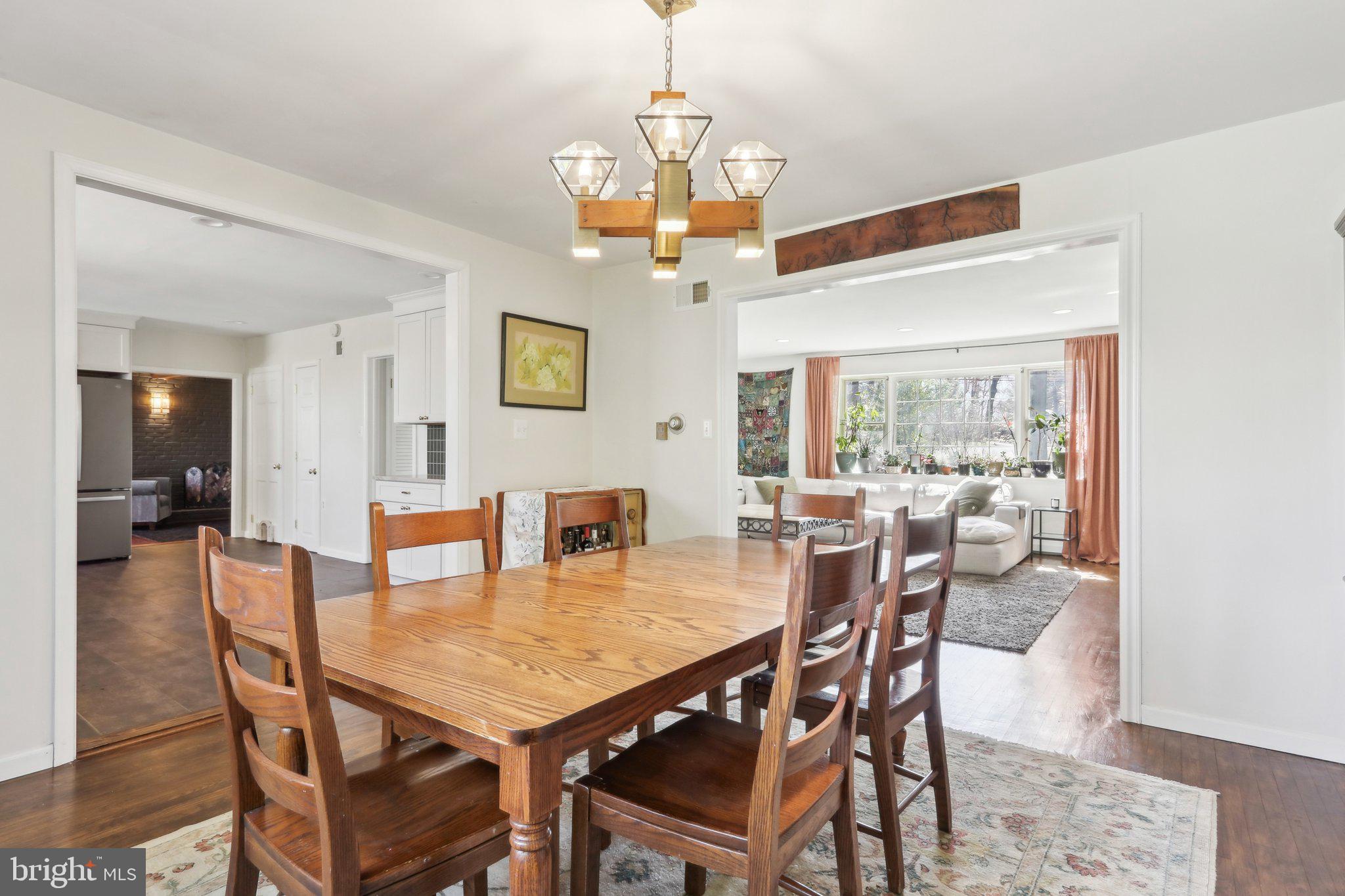 2305 Huntingdon Road Huntingdon Valley, PA 19006 - Photo 5 of 57 a dining room with wooden floor a chandelier a wooden table and chairs