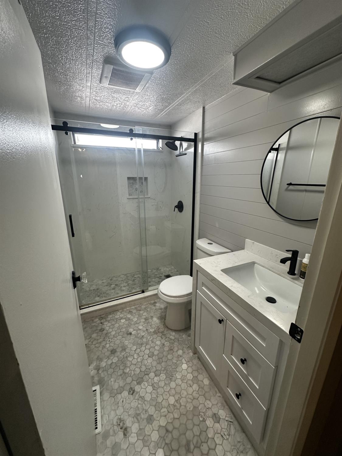 15820 South Harlan Road, Unit 16 Lathrop, CA 95330 - Photo 11 of 16 a bathroom with a granite countertop sink toilet a mirror and shower