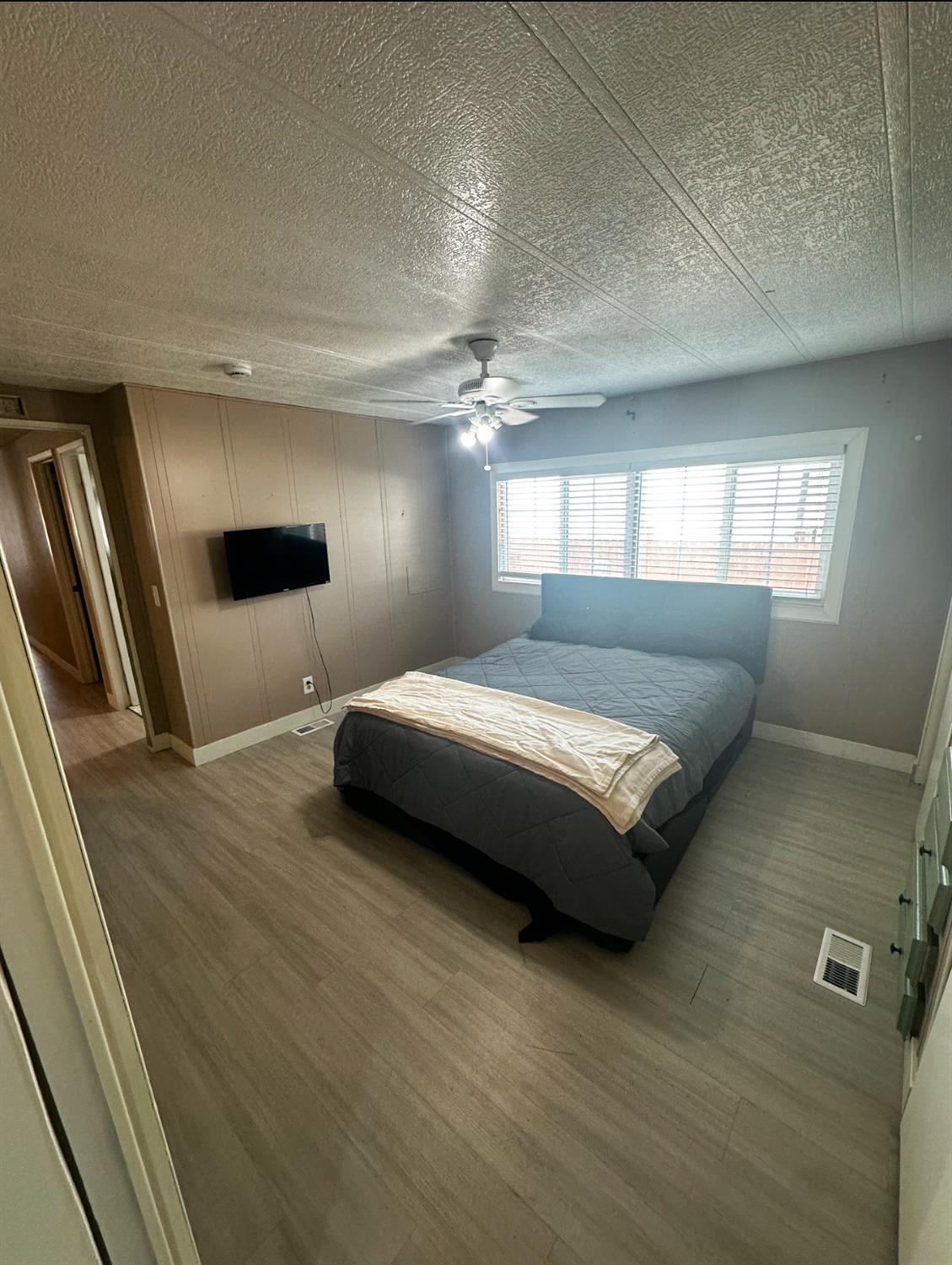 15820 South Harlan Road, Unit 16 Lathrop, CA 95330 - Photo 8 of 16 a bedroom with a bed and a large window