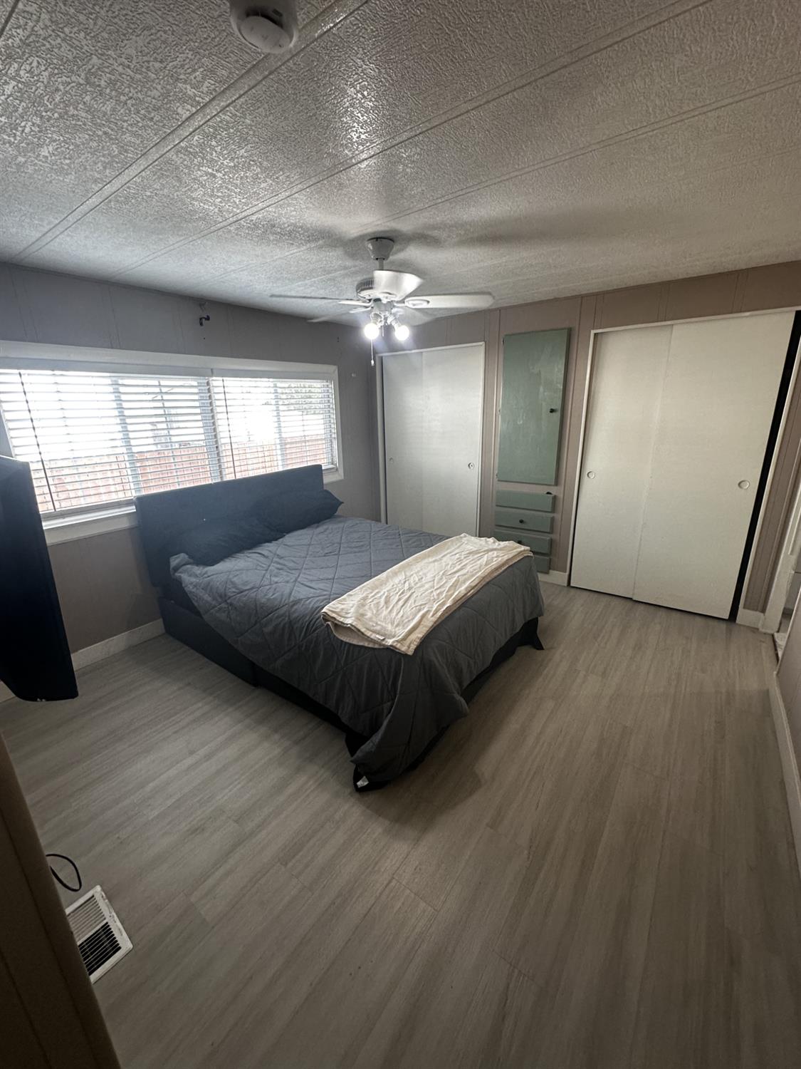 15820 South Harlan Road, Unit 16 Lathrop, CA 95330 - Photo 9 of 16 a bedroom with a large bed and a chandelier