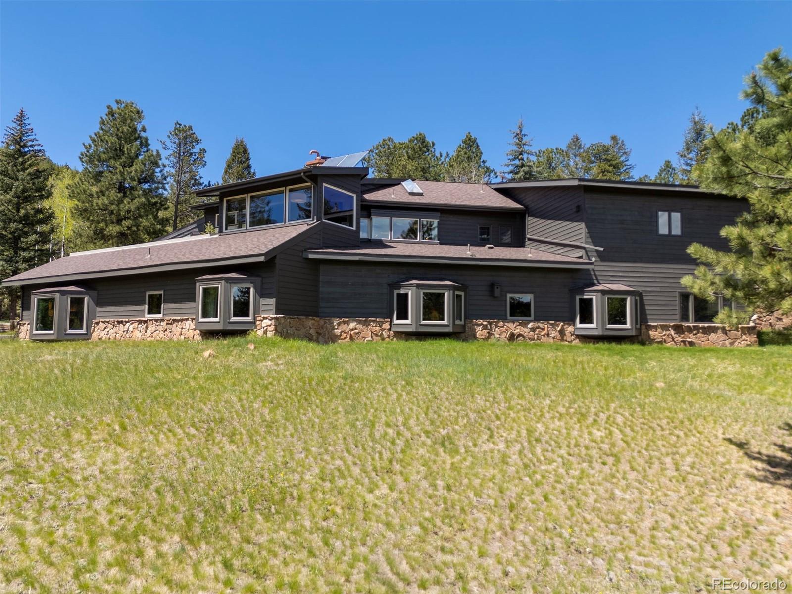1323 South Snyder Gulch Road Evergreen, CO 80439 - Photo 43 of 47 a front view of a house with a garden