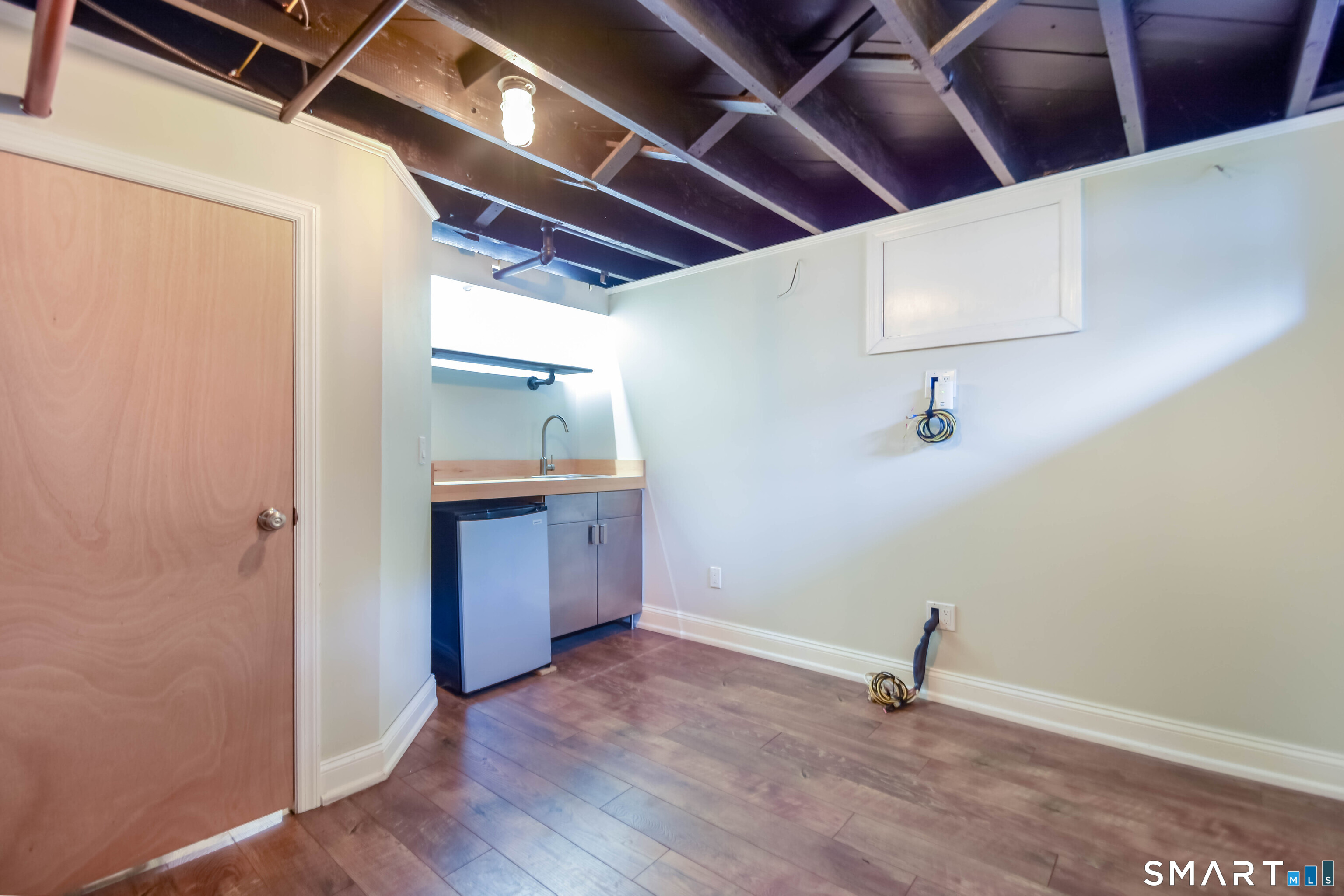 234 North Pine Creek Road Fairfield, CT 06824 - Photo 25 of 28 Partially Finished Basement with Small Refrigerator and Wet Bar