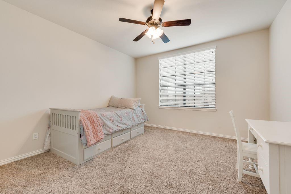 311 Covington Lane Ovilla, TX 75154 - Photo 25 of 29 a spacious bedroom with a bed and a chandelier