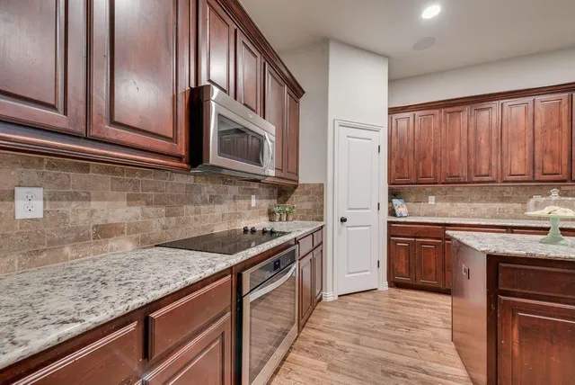 a kitchen with stainless steel appliances granite countertop a sink stove and refrigerator