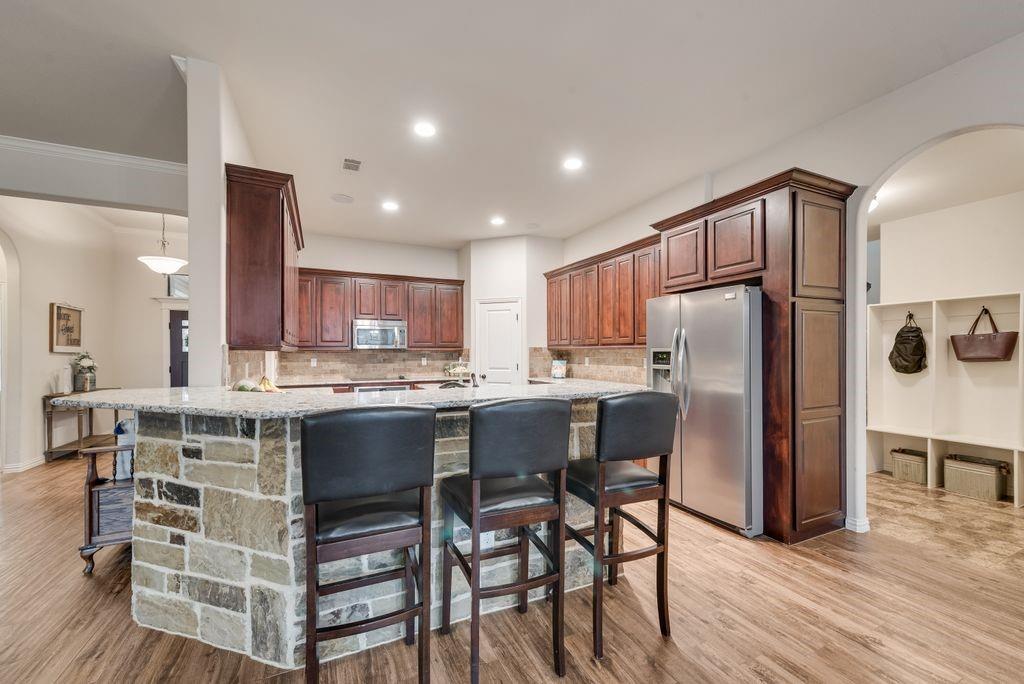 311 Covington Lane Ovilla, TX 75154 - Photo 9 of 29 a kitchen with a table chairs refrigerator and cabinets