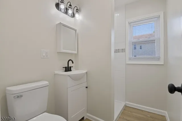 a bathroom with a toilet a sink and mirror