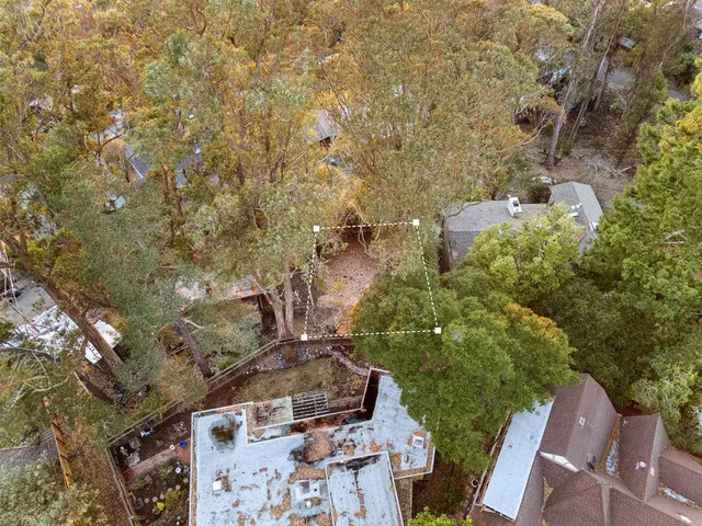 an aerial view of residential houses with city and green space