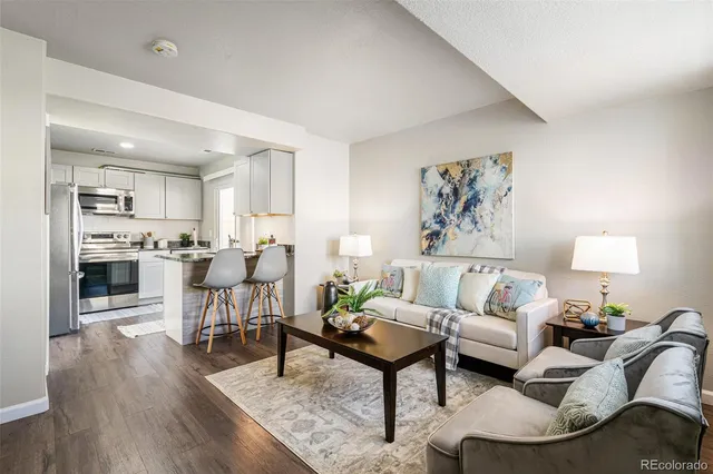 a living room with furniture and view of kitchen