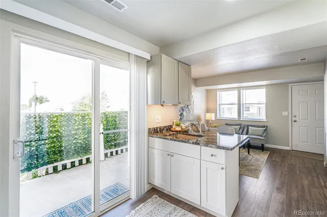 a open kitchen with white cabinets and wooden floor