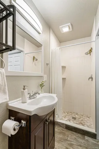 a bathroom with a sink a toilet and shower