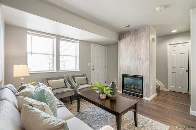 a living room with furniture a fireplace and a table