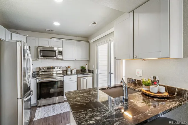 a kitchen with sink cabinets and stainless steel appliances