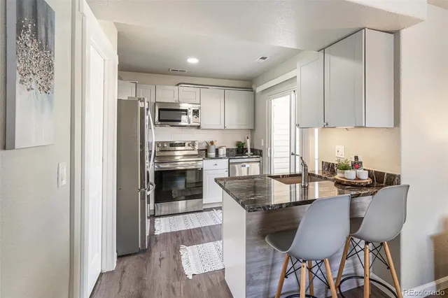 a kitchen with kitchen island a stove a table and chairs in it