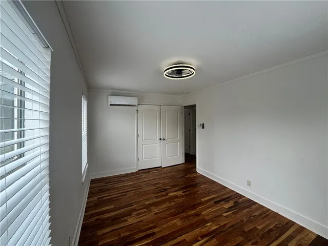 a view of a room with wooden floor and white walls