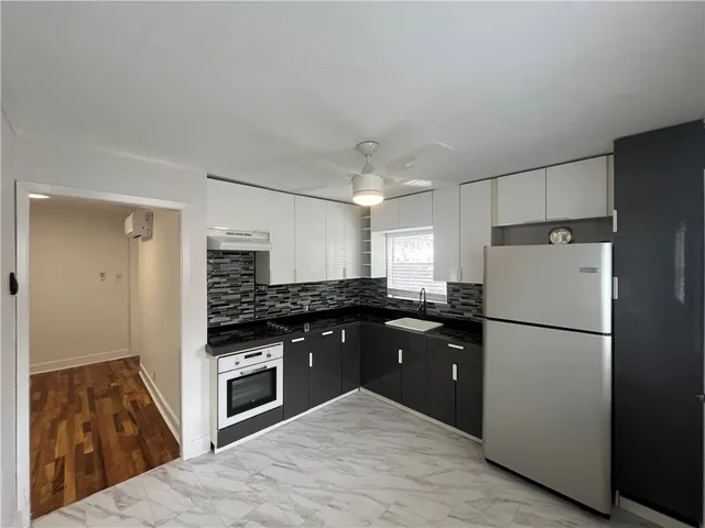 a kitchen with a refrigerator a stove and wooden cabinets