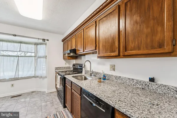 a kitchen with stainless steel appliances granite countertop a sink a stove and cabinets