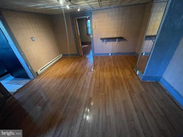 a view of empty room with wooden floor